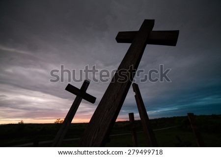 Silhouette the cross over blurred sunset background.