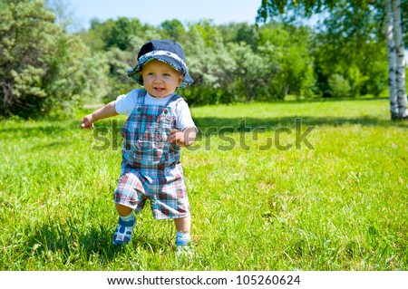 Toddler taking first steps in a park