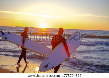 Similar – Image, Stock Photo Anonymous surfer friends at the beach with surfboards