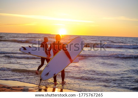 Similar – Image, Stock Photo Anonymous surfer friends at the beach with surfboards