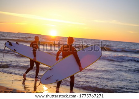 Similar – Image, Stock Photo Anonymous surfer friends at the beach with surfboards