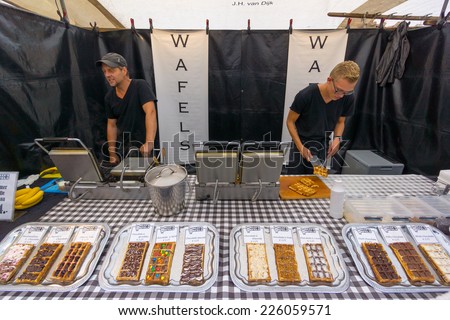 AMSTERDAM - AUGUST 30: People cook traditional Dutch waffles on the market on August 30, 2014 in Amsterdam.