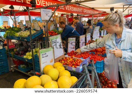 AMSTERDAM - AUGUST 30: People buy vegetables at the market on August 30, 2014 in Amsterdam.