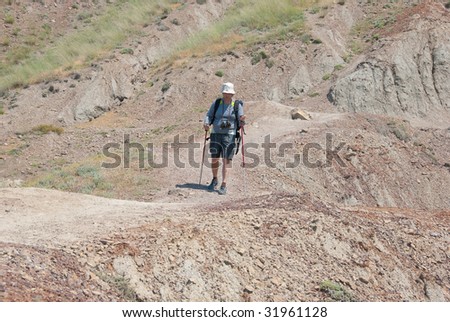 Alone backpacker hikes on a desert path