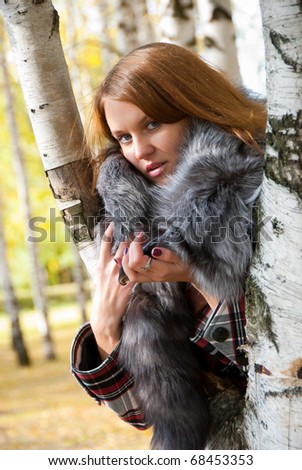 Portrait of a girl with a fur collar in the birch forest