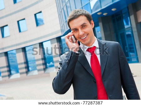 Smiling businessman calling in a modern downtown area