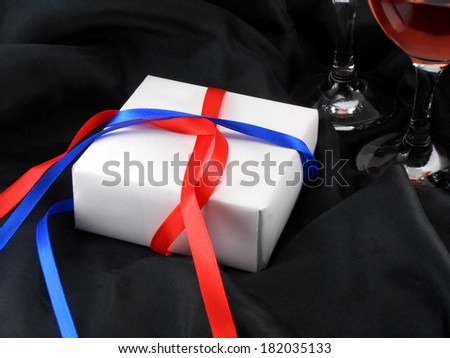 wine glass cup and white present on black background