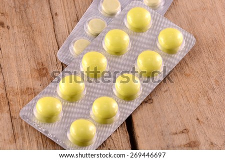 Medicinal pills piled up a bunch of closeup on wooden plate