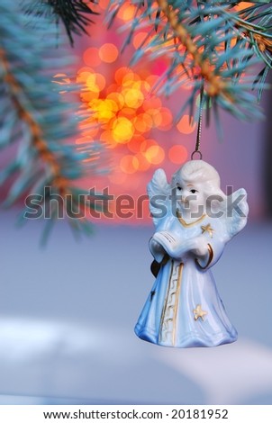 Christmas ball - angel on background of sprig tree and Xmas light.
