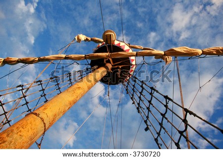 Sailing ship\'s furled canvas sails and complicated rope