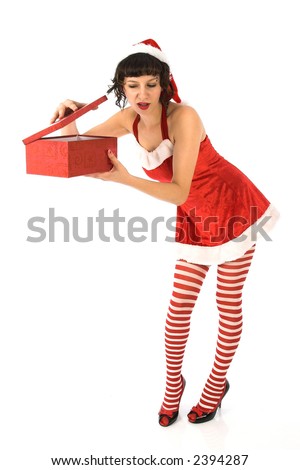Girl in santa outfit peering into present