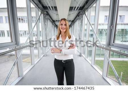 Businesswoman standing in a modern Building with a white shirt and black pants