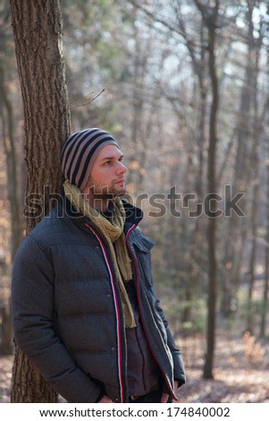 Man standing in the forest during wintertime with a thick jacket