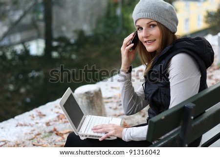 Woman on the Phone and Laptop next to a River