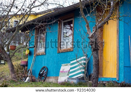 Untidy Small Blue House With A Yellow Door