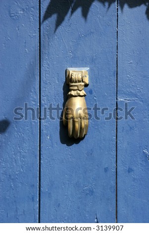 A golden hand on a blue door