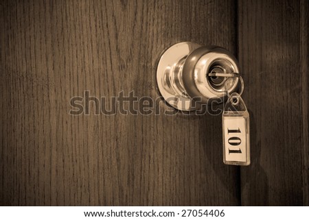 Close up of hotel key in door-handle lock. Shallow DOF.