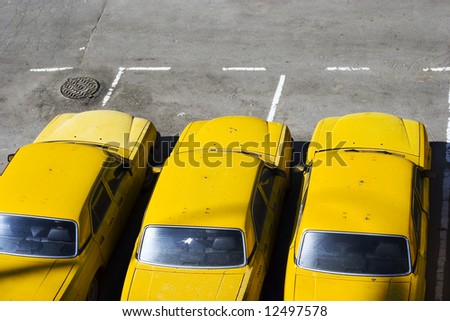 The three yellow taxi cars on parking