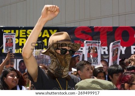 Los Angeles, CA, USA - April 14, 2015:  Man wearing face mask raising hand for justice during Stop Murder by Police.