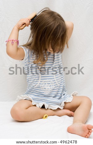 the little cute girl brushing her hair