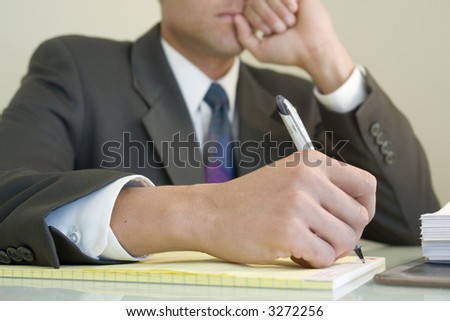 Business man writing on legal notepad