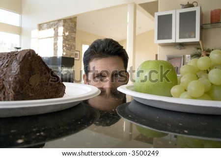 Man decides between cake and grapes