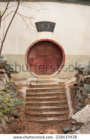 Steps lead to an Oriental circular red door near Boya Pagoda at Peking University