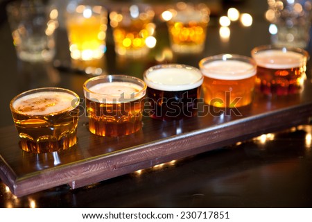 Set of glasses of light and dark beer on a pub background.