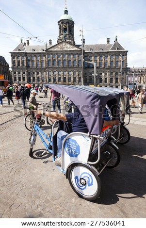 Amsterdam, Netherlands, 10 may 2015: bicycle taxi on Dam Square in front of Amsterdam royal palace in the netherlands