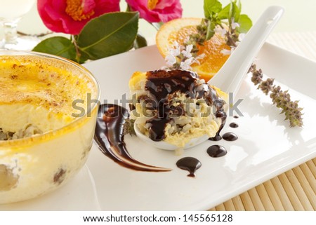 Spoonful of fresh baked rice custard with chocolate sauce straight from the oven ready to serve.