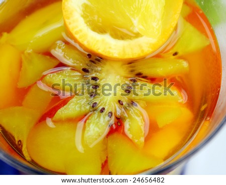 Fresh sliced tropical fruit set in pineapple jelly in a glass.