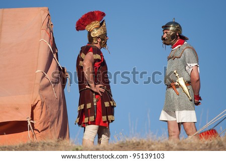 VALERIA, SPAIN - AUGUST 15: Unidentified performers dressed like Roman soldiers talk during a Roman exhibition, in the ancient ruins of  \