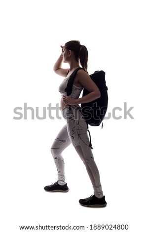 Backlit silhouette of a female model posing as a hiker on a white background wearing a backpack.  The image has copy space and isolated for composite cut outs to add backgrounds Сток-фото © 