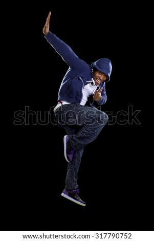 Black urban break dancer wearing a blue hoodie and jumping.  The man is energetic and active.