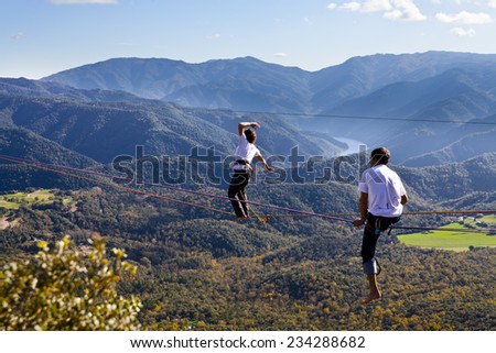 TAVERTET - NOVEMBER 16: Man practicing highline in Spain on November 16, 2014. Highline is a balance sport that consists walking through a rope clamped between two points and great height below.
