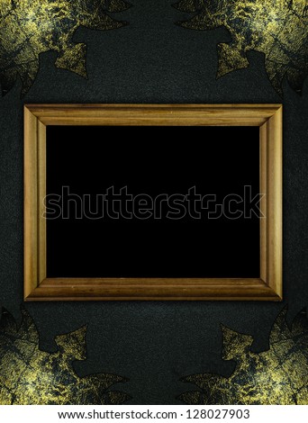 Template for inscription. Black texture with worn gold corners and wooden frame