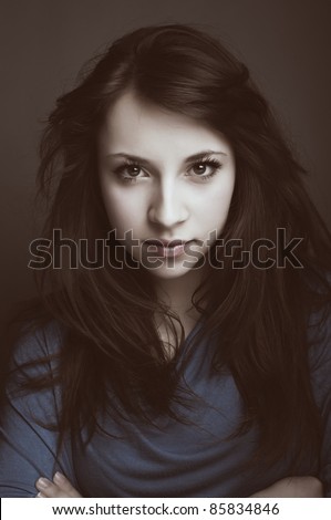 Close up photo of a young woman smirking, desaturated brownish retro colors. Adobe Rgb color space