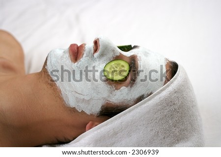 someone having a cleansing mask with cucumber