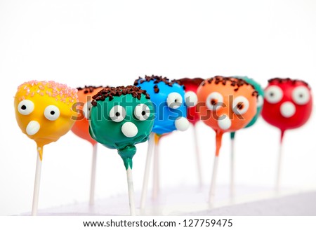Six cake pops with funny faces isolated on white background