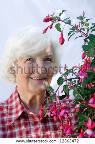 Senior woman with fuchsia flower plant