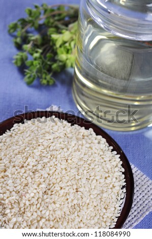 Sesame seeds in ceramic plate with  Sesame oil on table. Small shallow DOF