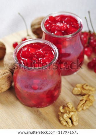 Jars with homemade viburnum jam on a wooden cutting board