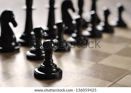 chess pieces on a wooden desk closeup