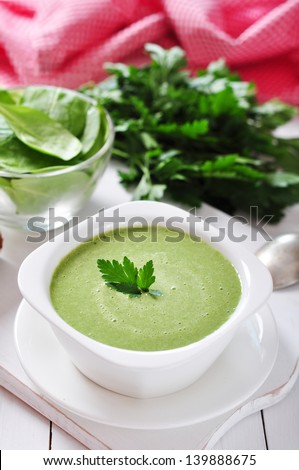 spinach soup in a bowl on a wooden background