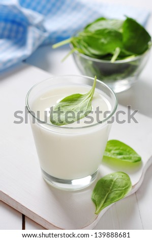 Yogurt with spinach in a glass on wooden cutting board