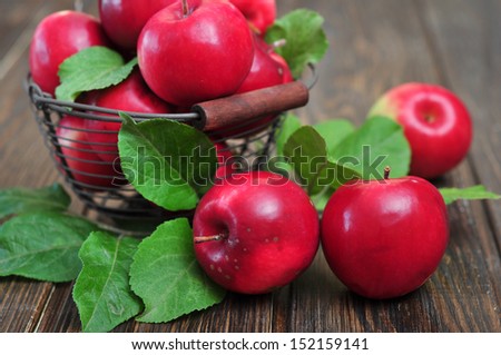 Apples in metal basket on wooden background