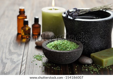 Spa concept. Sea salt in stone bowl with candle and herbal soap