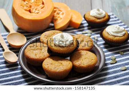 Pumpkin Muffins with whipped cream on blue striped background