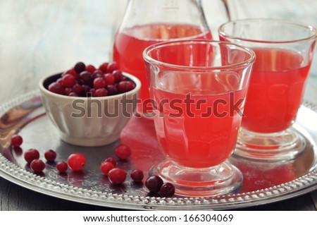Cranberry juice in glass with fresh berry on metal tray