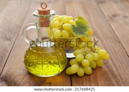Grape seed oil in a glass jar on wooden background